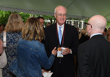 People talking at an event. Links to Gifts of Life Insurance