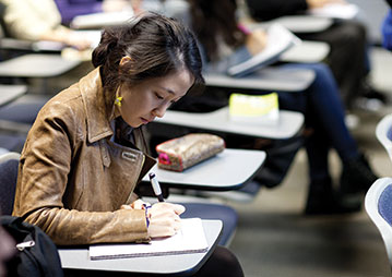 A student writing in class. Links to Closely Held Business Stock